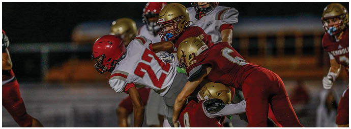 Adults wearing football uniforms with “Seminoles" on their jerseys are running on a field during a game or practice. Description generated by AI