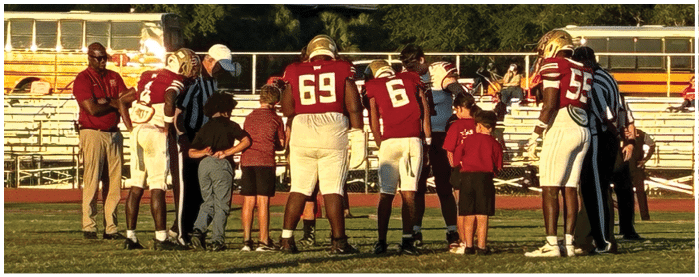 A football game is taking place with players on the field. Description generated by AI