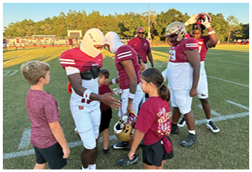 A football game is taking place with players on the field. Description generated by AI