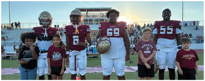 A football game is taking place with players on the field. Description generated by AI