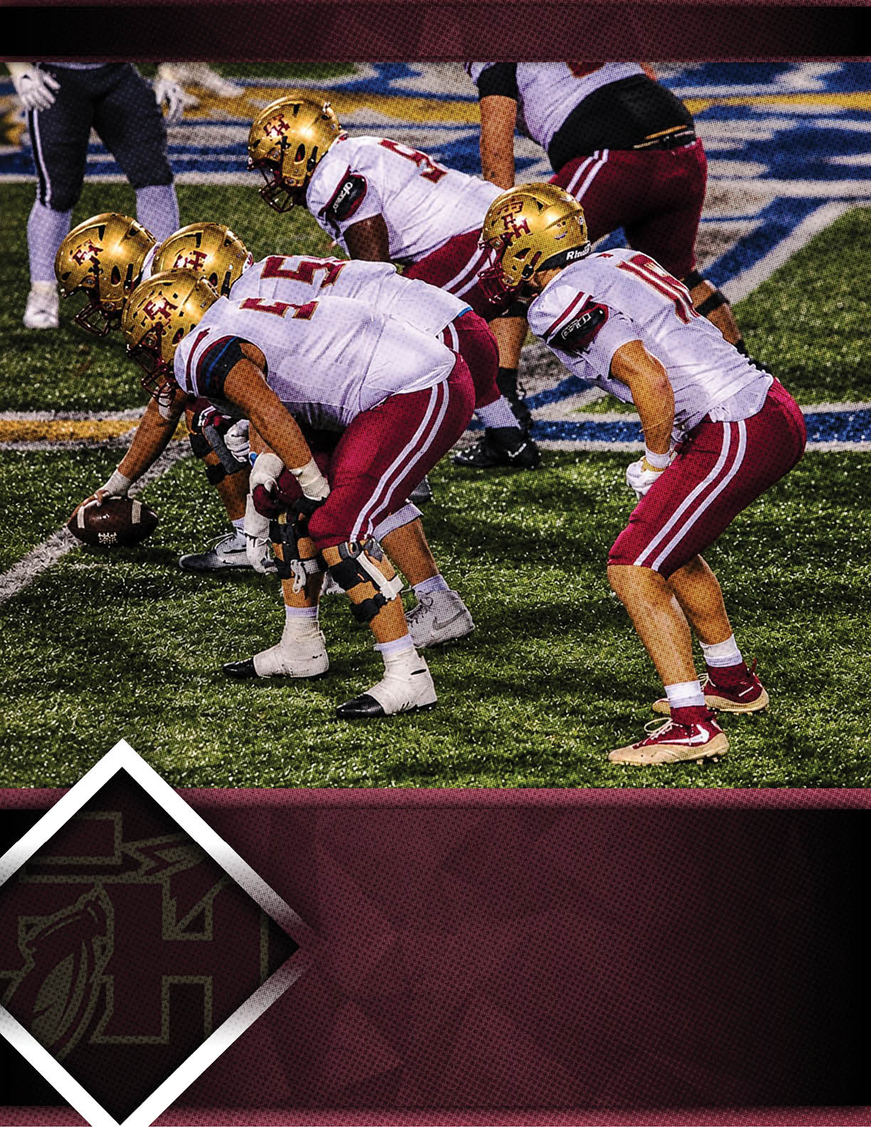 A group of people in football uniforms with gold helmets and white and maroon jerseys are lined up on a green field preparing for a play. Description generated by AI