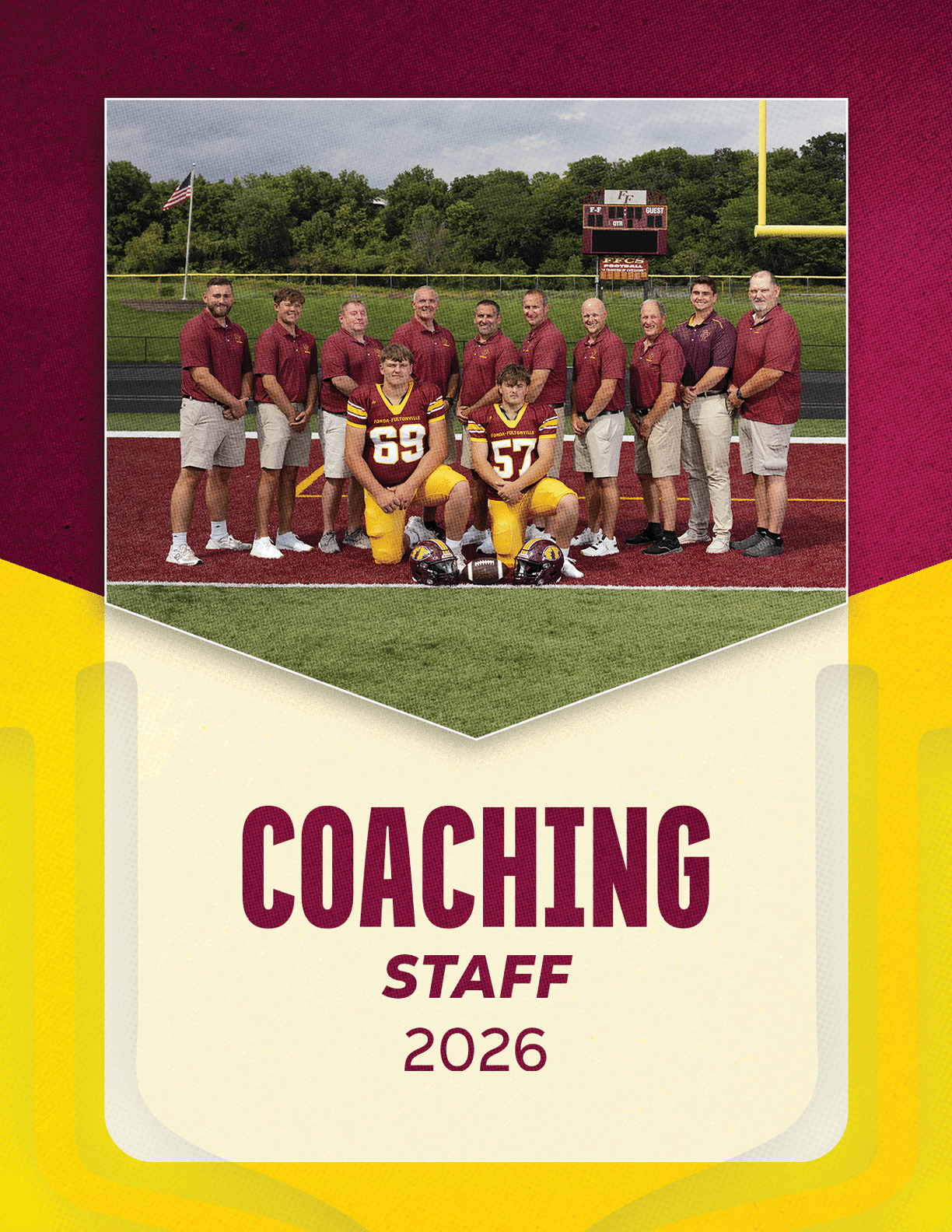 A group of adults wearing matching maroon shirts and khaki shorts stand behind two adults in football uniforms kneeling on a football field with a scoreboard and goalpost in the background, with the text coaching staff 2026 below. Description generated by AI