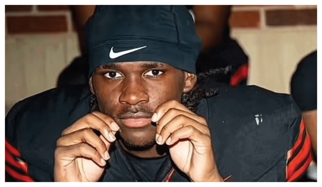 A football player wearing a blue and red jersey. Description generated by AI