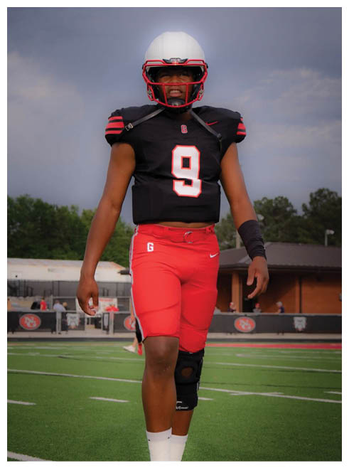 Two football players wearing black jerseys and holding hands. Description generated by AI