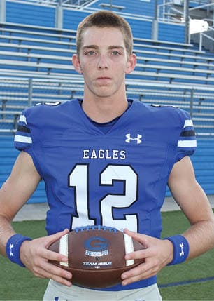 A young man wearing a white and black jersey with the number 14 on it. Description generated by AI