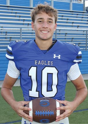 A young man wearing a white and black jersey with the number 14 on it. Description generated by AI