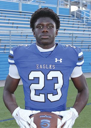 A young man wearing a white and black jersey with the number 14 on it. Description generated by AI