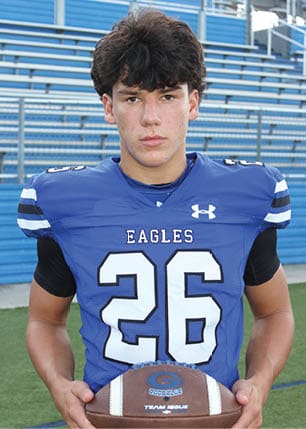 A young man wearing a white and black jersey with the number 14 on it. Description generated by AI