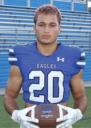A young man wearing a white and black jersey with the number 14 on it. Description generated by AI