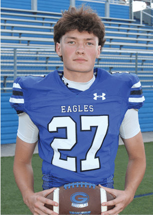 A young man wearing a white and black jersey with the number 14 on it. Description generated by AI