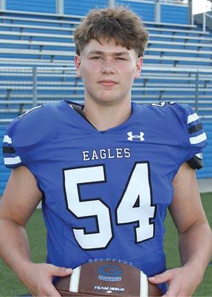 A young man wearing a white and black jersey with the number 14 on it. Description generated by AI