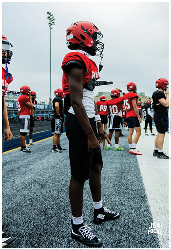 A football player running on the field. Description generated by AI