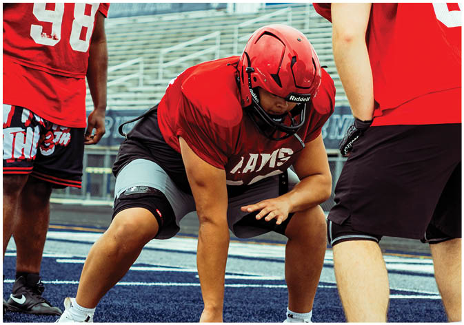 A group of football players wearing black and white uniforms. Description generated by AI