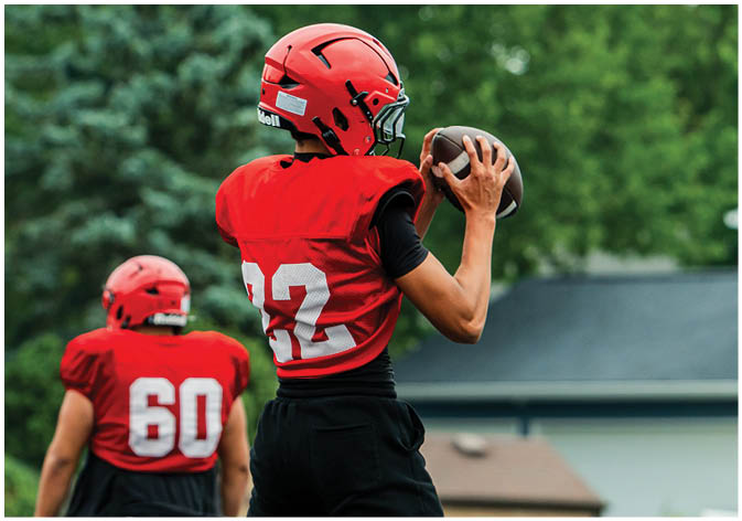 A group of football players wearing black and white uniforms. Description generated by AI