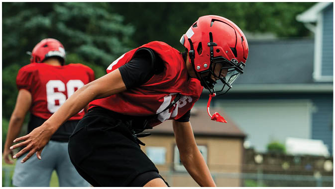 A group of football players on a field. Description generated by AI