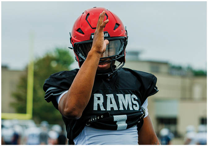 A group of football players wearing black and white uniforms. Description generated by AI