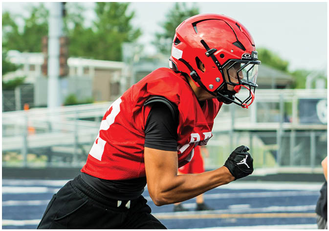 A group of football players wearing black and white uniforms. Description generated by AI