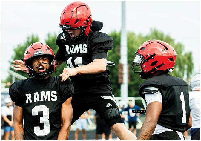 A group of football players wearing black and white uniforms. Description generated by AI