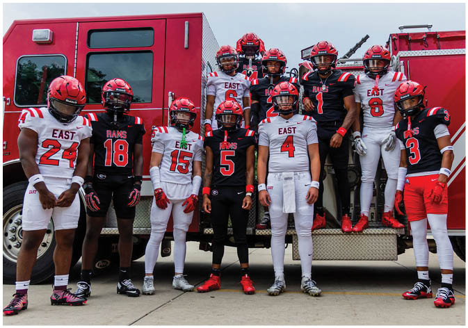 A group of football players wearing black and white uniforms. Description generated by AI