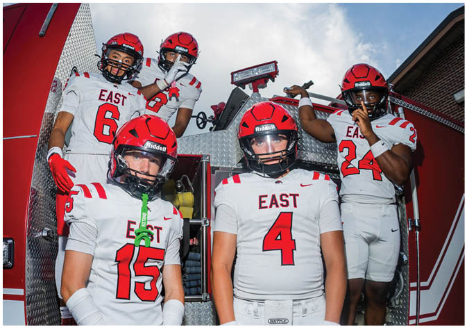 A group of football players wearing black and white uniforms. Description generated by AI