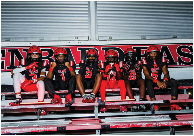A group of football players wearing black and white uniforms. Description generated by AI