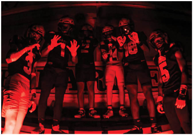 A group of football players wearing black and white uniforms. Description generated by AI