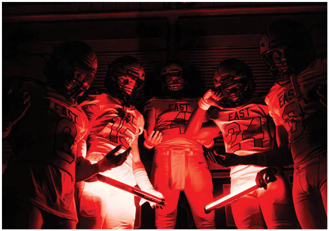 A group of football players wearing black and white uniforms. Description generated by AI