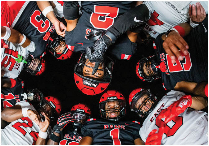 A group of football players wearing black and white uniforms. Description generated by AI
