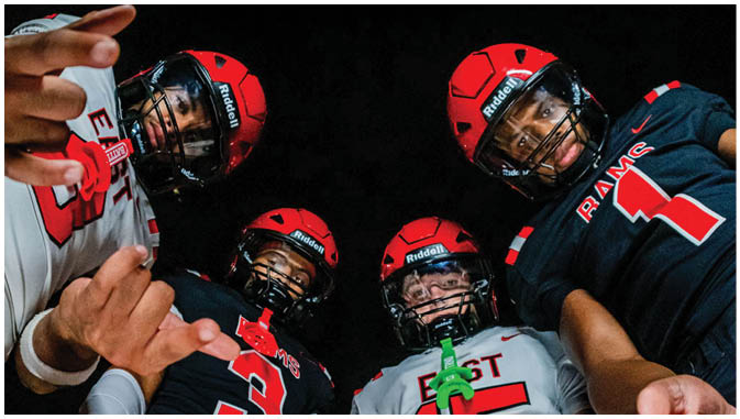 A group of football players on a field. Description generated by AI