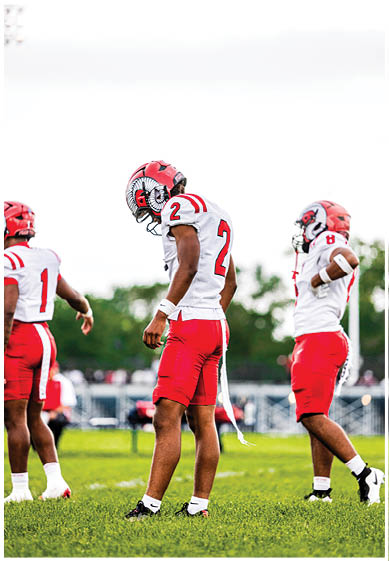 A football player wearing a blue and red jersey. Description generated by AI