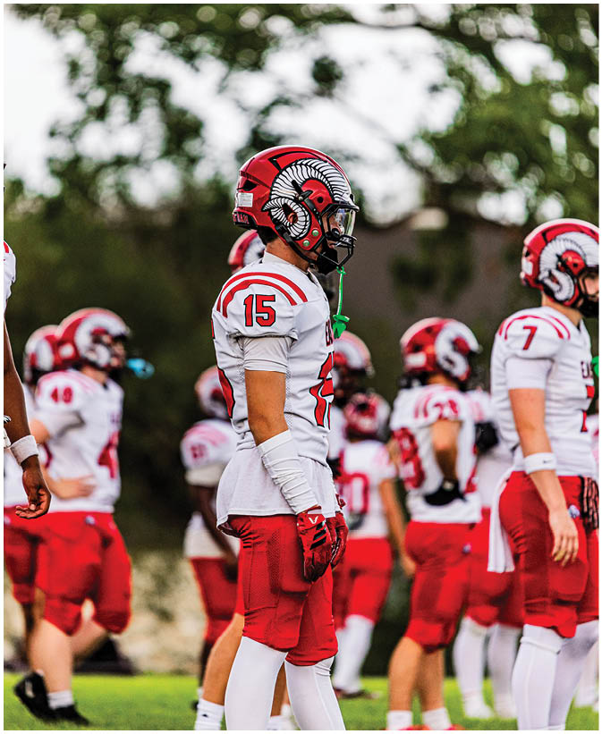 A group of football players on a field. Description generated by AI