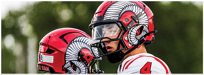 A football game is taking place on a field with players wearing blue and white uniforms. Description generated by AI