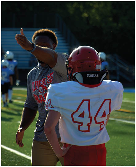 A football player catching a ball. Description generated by AI
