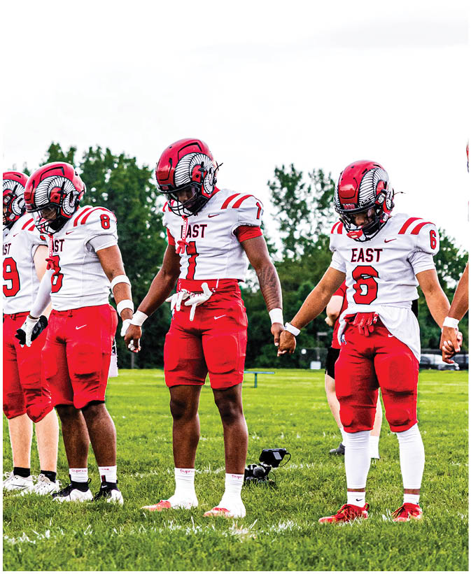 A group of football players on a field. Description generated by AI