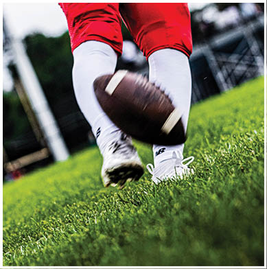 A football game is taking place with a group of men on the field. Description generated by AI