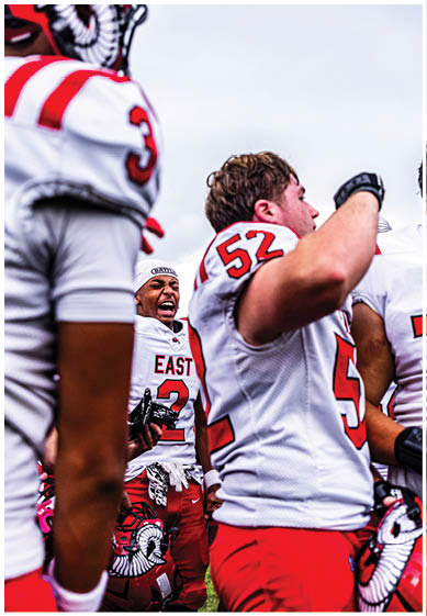 A football player wearing a blue and red jersey. Description generated by AI