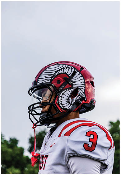 A football player wearing a blue and red jersey. Description generated by AI