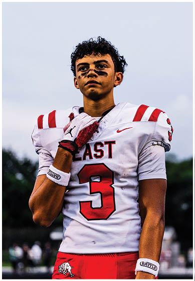 A football player wearing a blue and red jersey. Description generated by AI