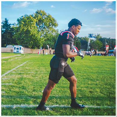 A football game is taking place with a group of men on the field. Description generated by AI
