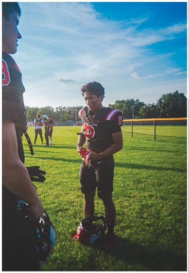 A football player wearing a blue and red jersey. Description generated by AI