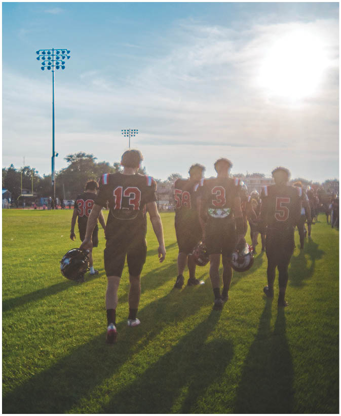 A group of football players on a field. Description generated by AI