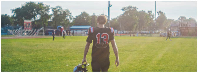 A football game is taking place on a field with players wearing blue and white uniforms. Description generated by AI