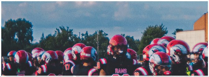 A football game is taking place on a field with players wearing blue and white uniforms. Description generated by AI