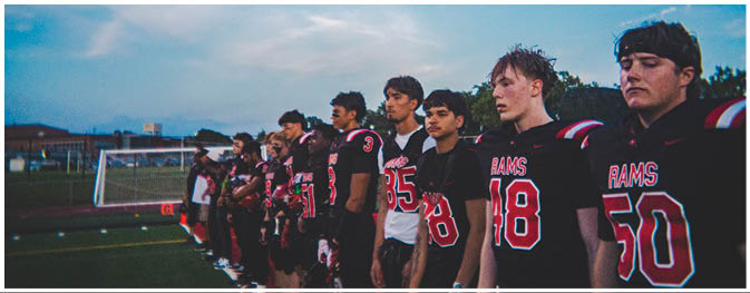 A group of football players on a field. Description generated by AI