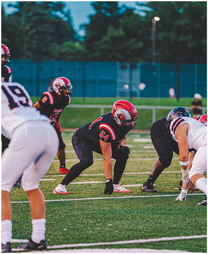 A group of football players on a field. Description generated by AI