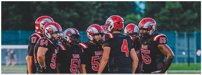 A football game is taking place on a field with players wearing blue and white uniforms. Description generated by AI