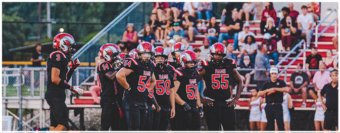 A group of football players on a field. Description generated by AI