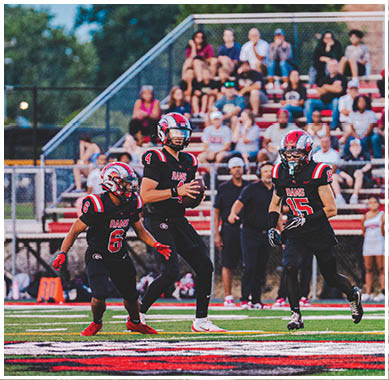 A football game is taking place with a group of men on the field. Description generated by AI