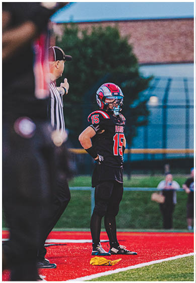 A football player wearing a blue and red jersey. Description generated by AI