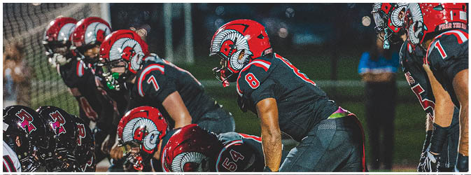 A football game is taking place on a field with players wearing blue and white uniforms. Description generated by AI